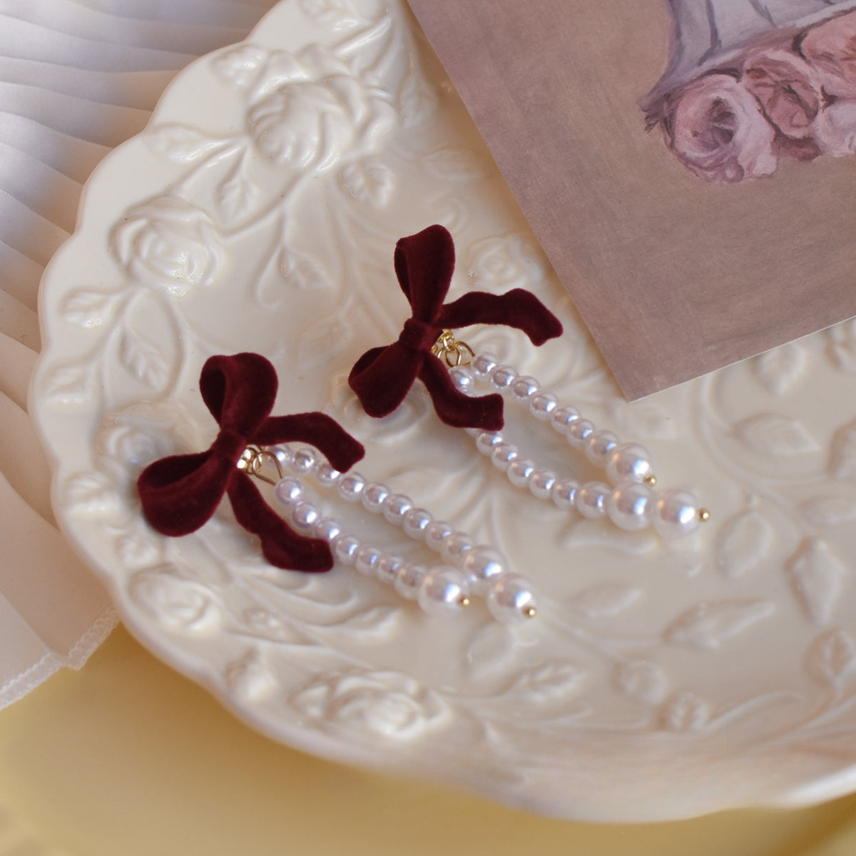 Close-up of burgundy velvet bow and pearl detail