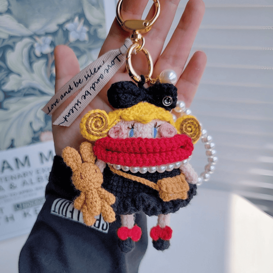 Rare Visual handcrafted doll keychain, black crochet bag charm with red scarf, blonde curls, and pearl handle, stylish handmade accessory