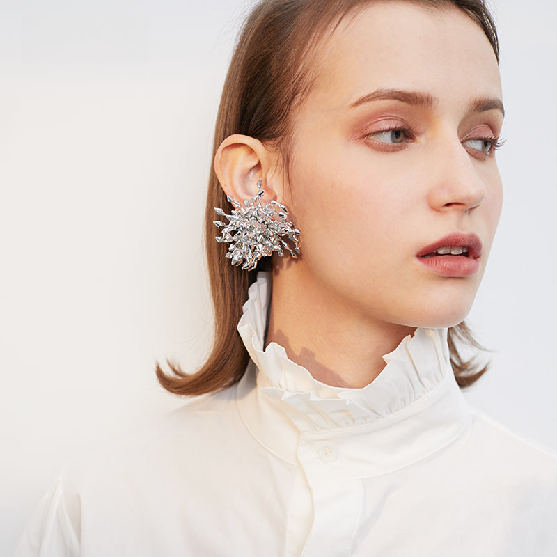 Close-up of Fireworks Silver Statement Earrings on model