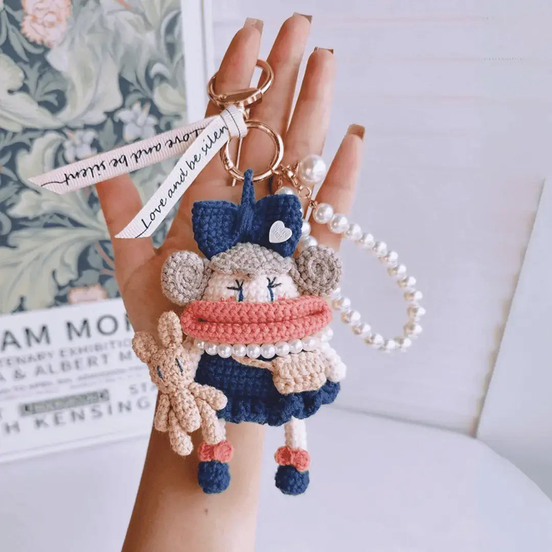 Hand hold a dark blue Handcrafted Curly Collection Doll Bag Charm 