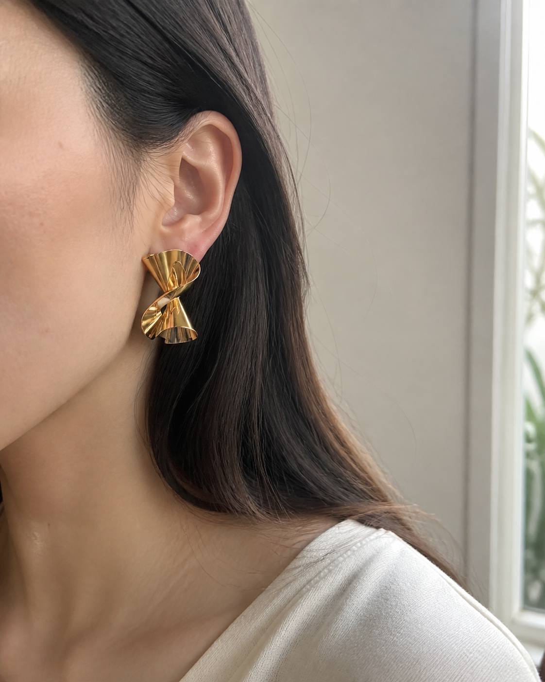 Gold twisted stud worn at everyday scale